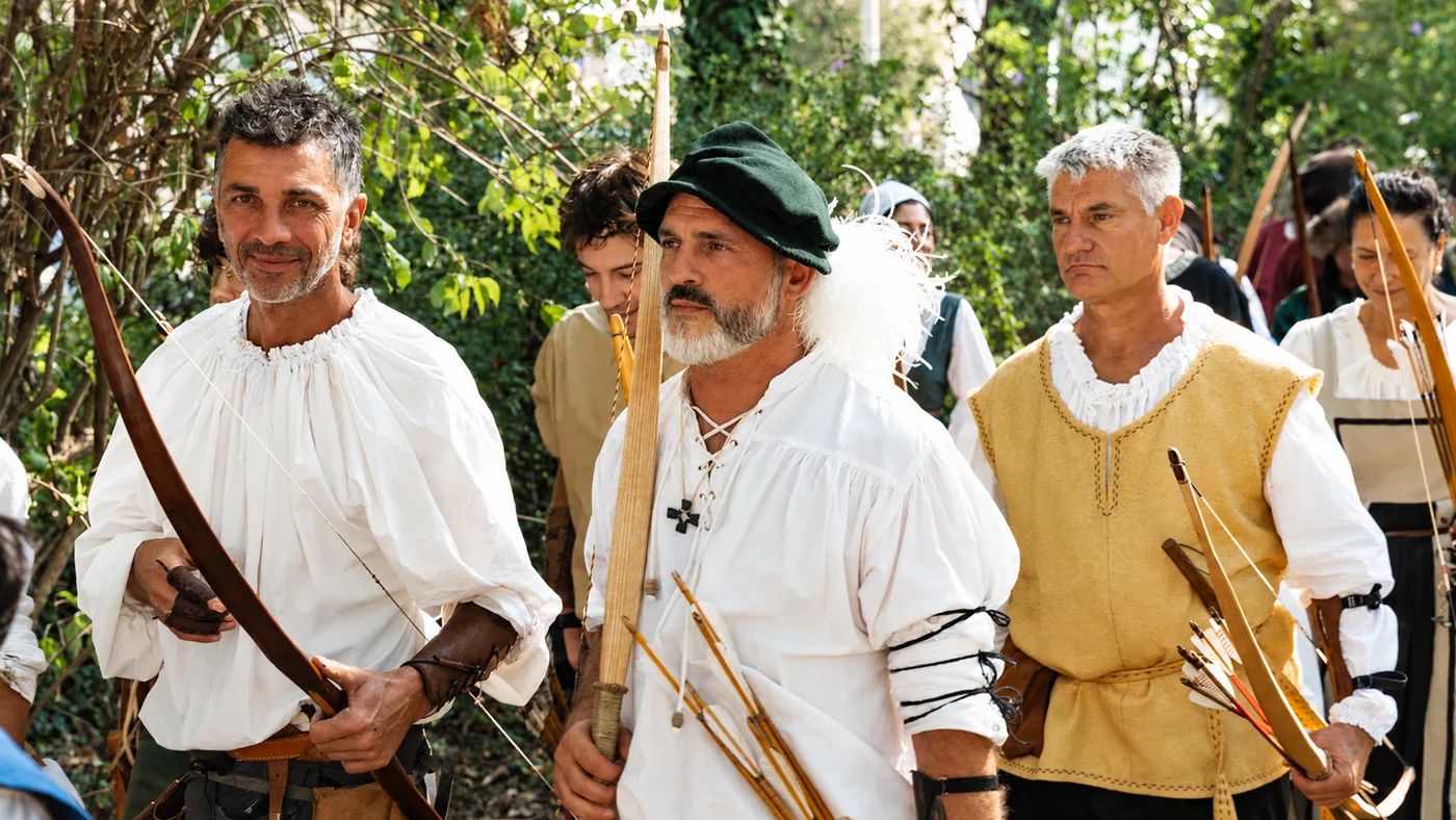 Tre Sambuchieri in costume rinascimentale con gli archi, nel bosco