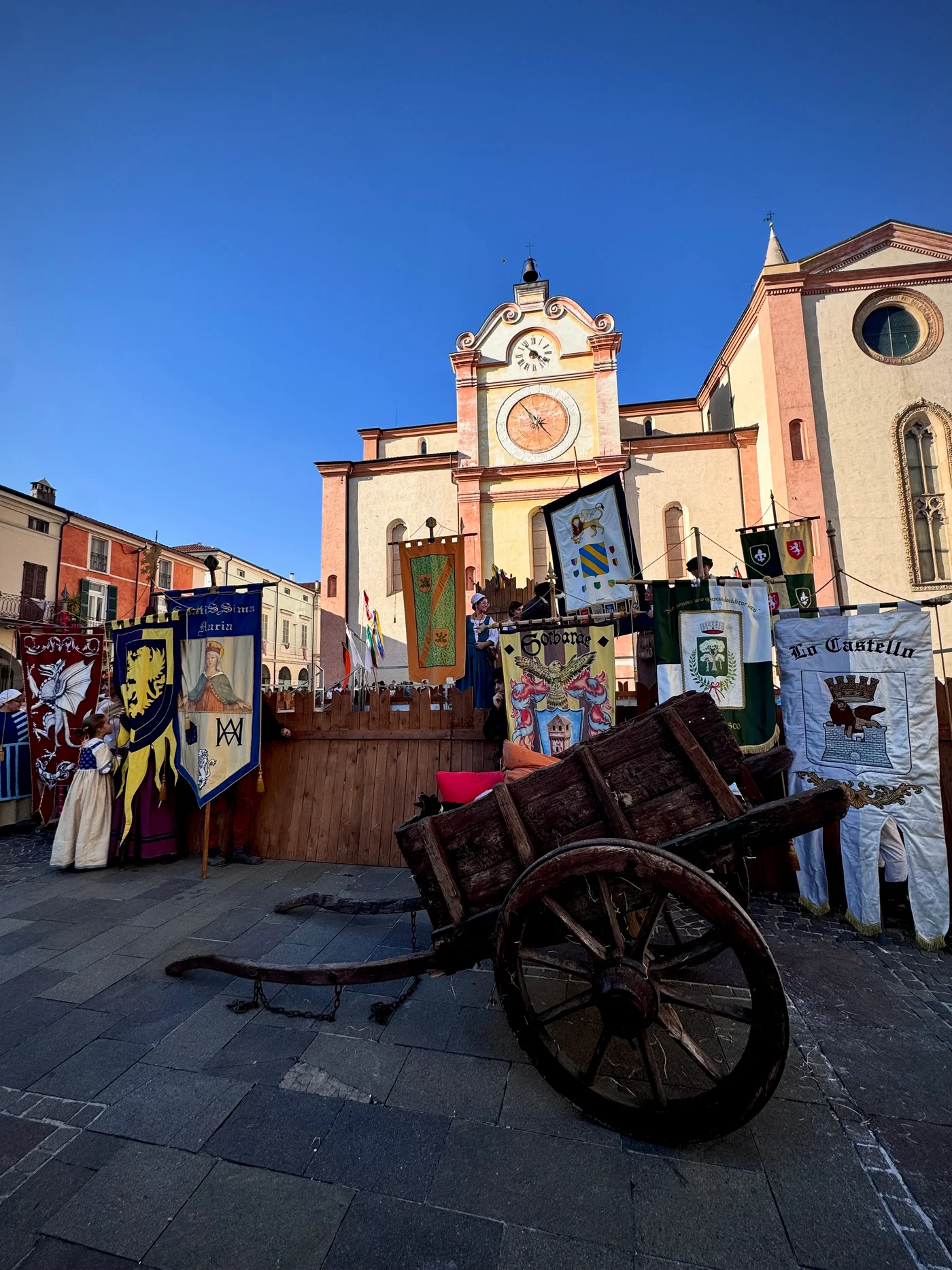 La piazza di Asola durante l'Assedio, con i gonfaloni delle contrade e un carro d'epoca davanti al Duomo
